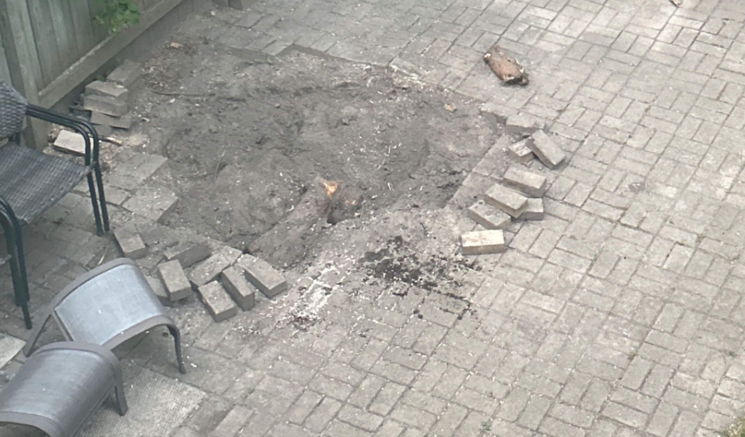 Large hole dug in brick patio